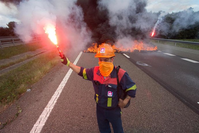 Un trabajador de Alcoa San Cibrao enciende una bengala durante una manifestación en la que han cortado la Autopista A6 con la quema de neumáticos, en Outeiro de Rei, Lugo, Galicia (España), a 22 de septiembre de 2020. 