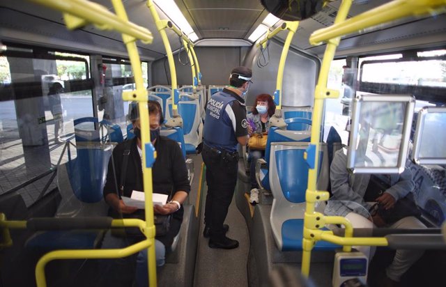 Un agente de la Policía Municipal de Madrid realiza un control de movilidad en una línea de autobús en Puente de Vallecas