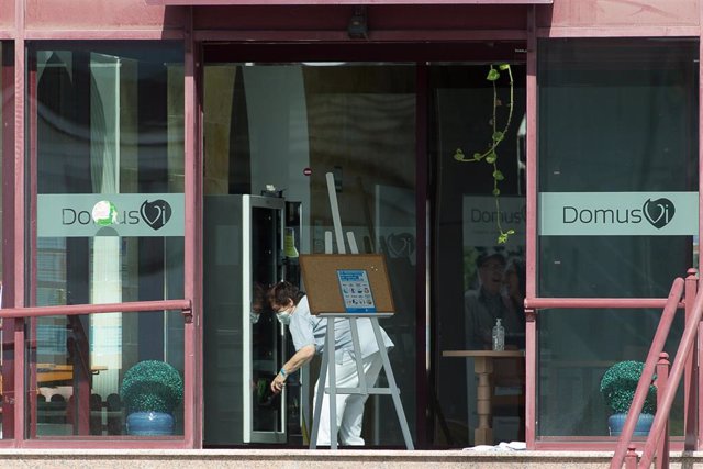 Un trabajador protegido es visto por uno de los cristales de la residencia de mayores DomusVi de Outeiro de Rei en Lugo.