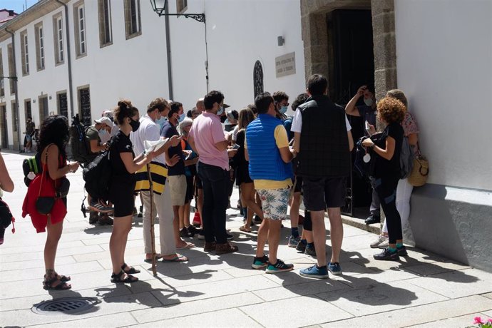 Peregrinos con mascarillas  esperando su turno para entrar en el albergue, en el primer verano de la pandamia Covid-19, Santiago de Compostela 26 de agosto del 2020