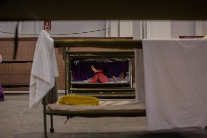 Un hombre descansa en su cama en el interior de las instalaciones del albergue de Fira Barcelona, habilitado por la crisis de la pandemia del coronavirus para 225 personas sin techo.  En Barcelona, Catalunya (España), a 28 de mayo de 2020.