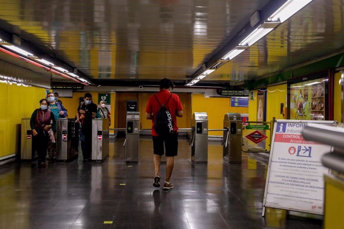 Varias personas pasan por los tornos de entrada del metro de Ciudad Lineal
