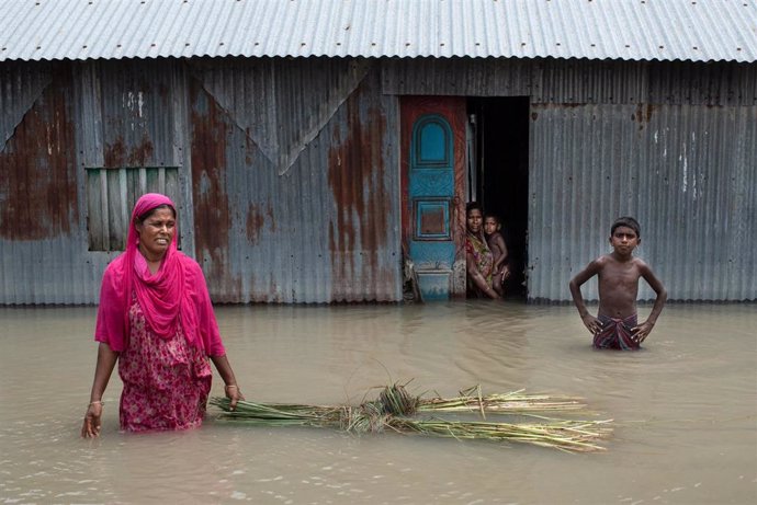 Una familia en una zona inundada en Bangladesh
