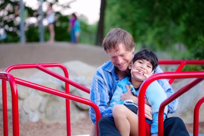 Padre en el parque con un hijo con parálisis cerebral