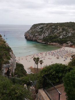 Bañistas en la Playa de Cala en Porter (Alaior, Menorca) un día nublado.