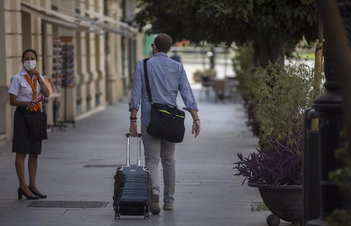 Un hombre con maleta pasea por el centro de la ciudad de Sevilla