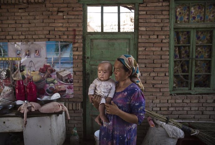 Una mujer uigur con su hijo en Xinjiang