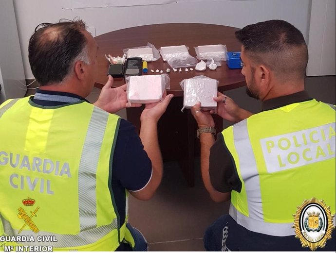 Agentes de la Guardia Civil y la Policía Local de Bollullos (Huelva) con la droga encontrada en el domicilio.