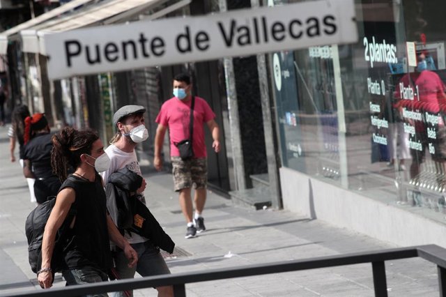 Vecinos pasean al lado del metro de Puente de Vallecas, en Madrid