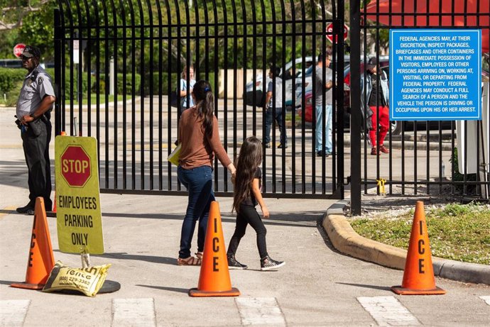 Una mujer y su hija en la entrada de un centro de la Agencia de Inmigración y Aduanas en Miramar, en Florida