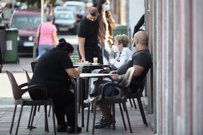 Personas sentadas en la terraza de un bar del distrito de Puente de Vallecas, Madrid (España), a 21 de septiembre de 2020. Puente de Vallecas es uno de los seis distritos de la capital que posee zonas básicas de salud en las que la Comunidad de Madrid a