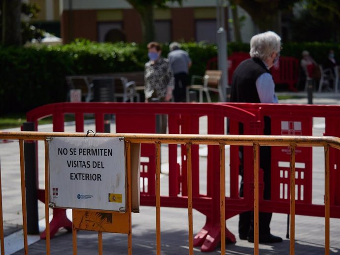 Una residente protegida con mascarilla de la Casa de Misericordia en el exterior del centro donde han habilitado una zona de visitas, con una distancia de seguridad determinada y unas medidas higiénicas, con el fin de evitar nuevos contagios de Covid-