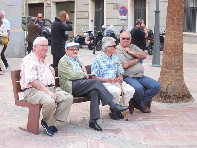 Imagen de un grupo de jubilados sentados en un banco. 
