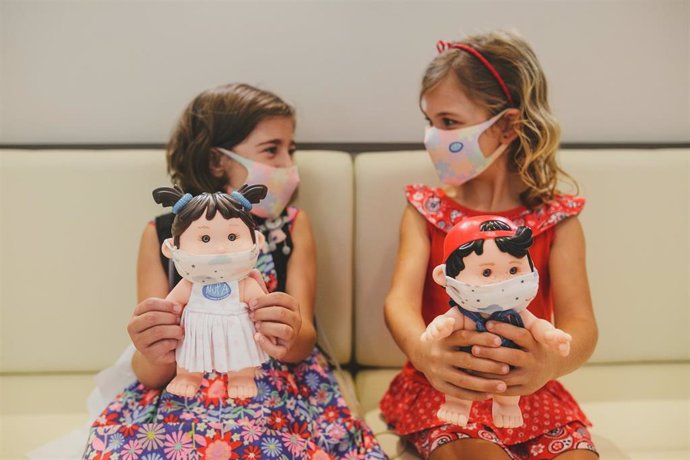 Nati y Adriana, dos niñas con fallo intestinal de la Asociación NUPA, sonríen enseñando a sus muñecos Nupancitos.