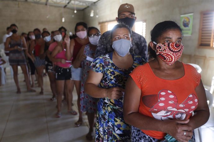 Un grupo de personas residentes de uno de los suburbios de Brasil esperan para recibir alimentos y material sanitario, en medio de la criris del coronavirus.