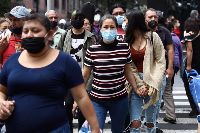 Varias personas pasean por las calles de México con mascarilla por el coronavirus. 