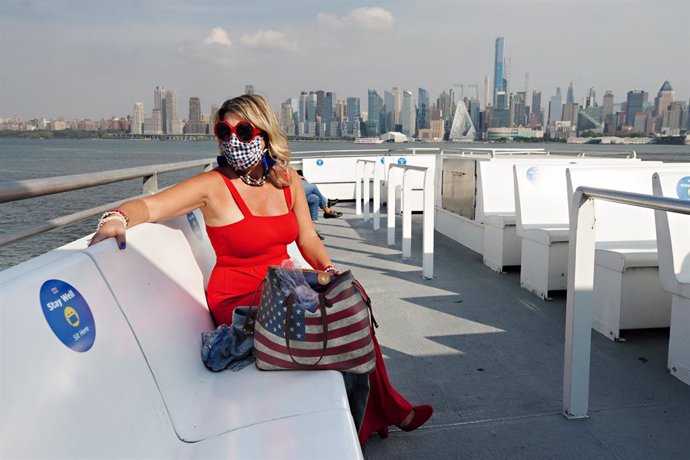 Mujer con mascarilla en un barco turístico en Nueva York durante la pandemia de 