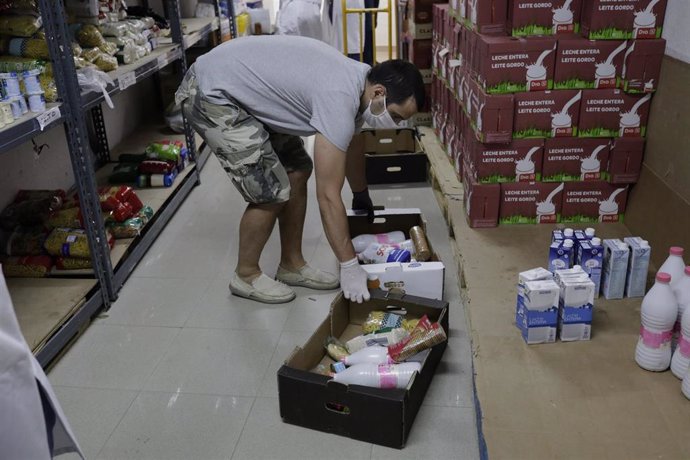 Voluntario prepara cajas con alimentos para entregarlos 