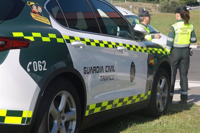 Un vehículo de la  Guardia Civil de Tráfico junto a dos agentes durante la campaña especial de la DGT de vigilancia y control de furgonetas, en el Km 0,1 de la M-511, en Madrid, a 28 de octubre de 2019.