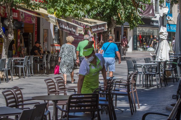 Una camarera limpia una mesa de una terraza de un bar en Benidorm durante el Día Mundial del Turismo 2020, en Benidorm, Alicante, Comunidad Valenciana (España) a 27 de septiembre de 2020.