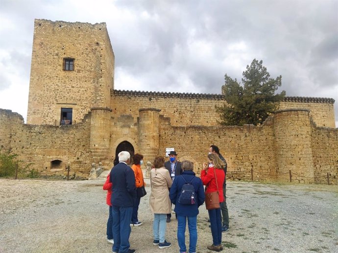 Uno de los guías del programa 'Viajero yo te enseñaré Segova' con los participantes en la visita a las puertas del Castillo de Pedraza.
