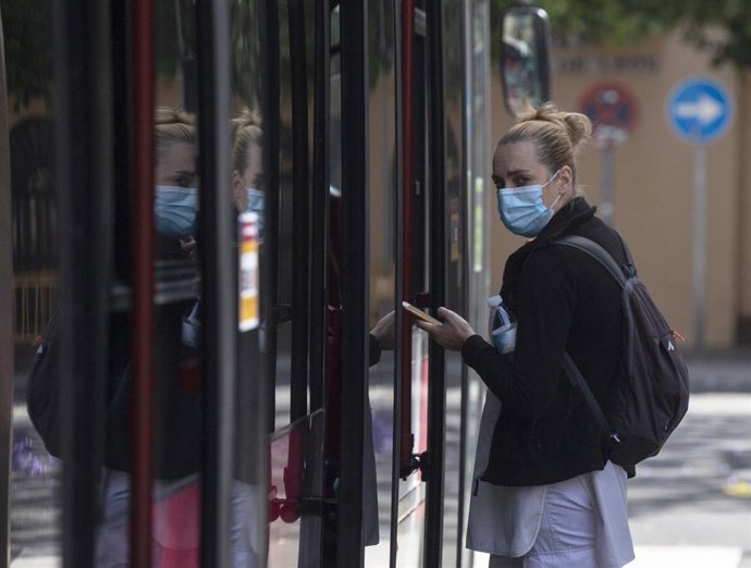 Una pasajera protegida con mascarilla antes de subir a un autobús de Tussam