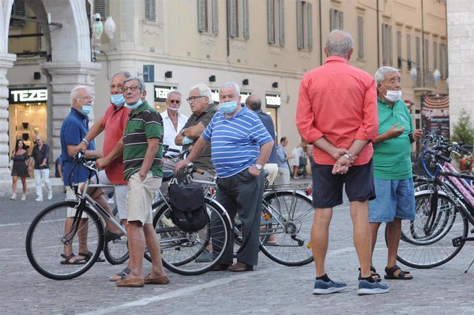 Hombres con mascarilla en una calle en Italia
