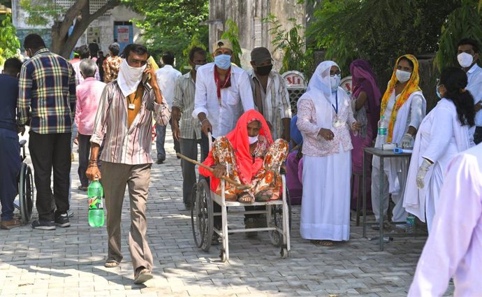 Un grupo de personas acude a votar durante las elecciones locales en el noroeste de India, en medio de la crsisi sanitaria provocada por la COVID-19.