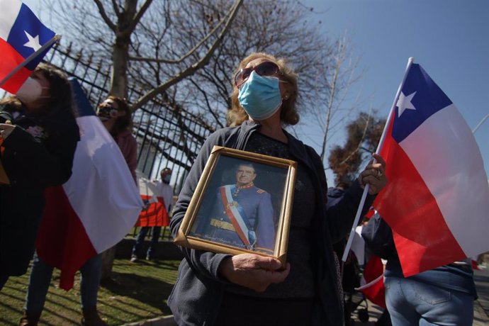 Una mujer sostiene un retrato de Augusto Pinochet
