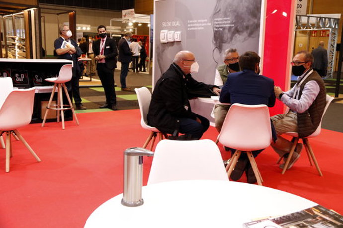 Gent amb mascareta asseguda a la taula d'un dels estands del Rebuild, el 29 de setembre del 2020 (Horitzontal).