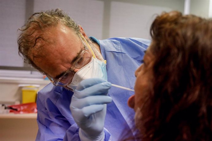 Un trabajador sanitario realiza una prueba PCR a una de las personas que ha acudido durante la jornada de hoy a realizarse un test al dispositivo instalado en el Centro de Especialidades El Arroyo, en Fuenlabrada, Madrid, (España), a 27 de agosto de 202