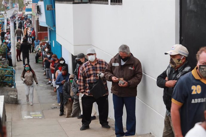 Un grupo de personas espera su turno parapoder acceder a una entidad bancaria en Liam, Perú, en el marco de la crisis sanitaria provocada por la COVID-19.