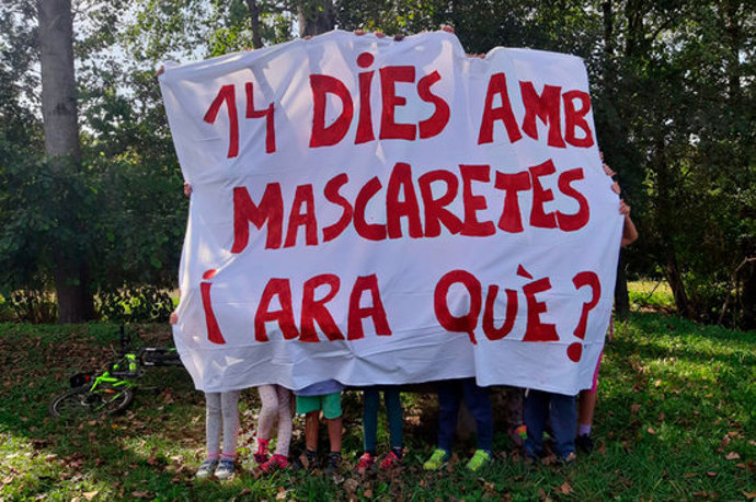 Pla general d'alguns alumnes de l'escola Finestres de Mieres aguantant una pancarta reivindicativa demanant que Educació revoqui l'ús de mascaretes a les aules el 29 de setembre de 2020 (Horitzontal)