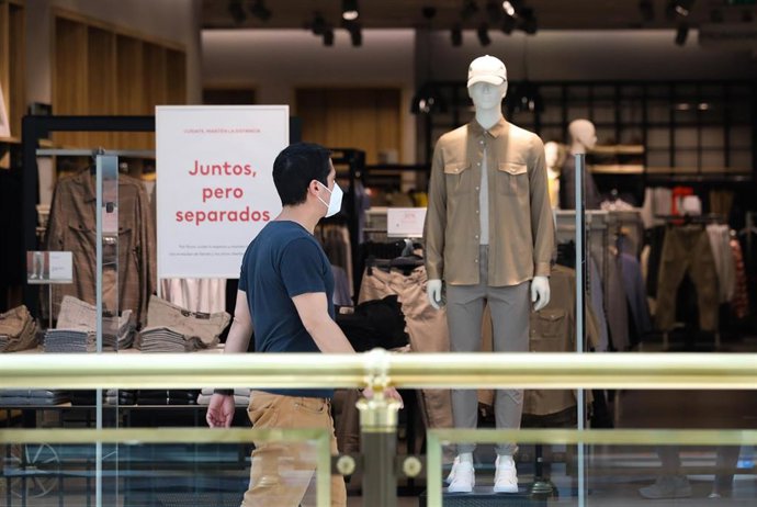 Un hombre pasa junto a una tienda de ropa del Centro Plaza Norte 2, La Cúpula de Madrid