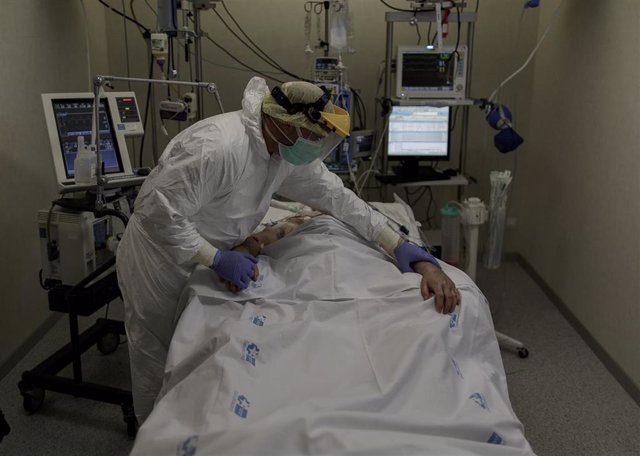 Personal sanitario totalmente protegido atiende a un paciente ingresado en la Unidad de Cuidados Intensivos del Hospital Infanta Sofía