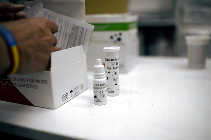 Una farmacéutica coloca una de las cajas de un test de antígeno para Covid-19, en Madrid