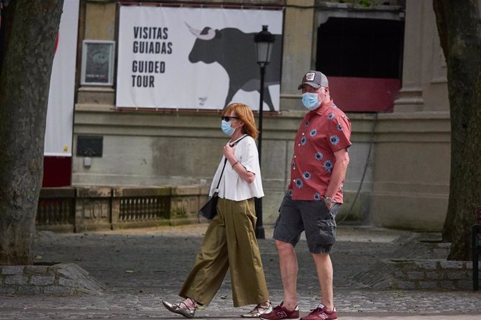 Dos turistas pasean delante de un cartel de 'Visitas guiadas' en Pamplona