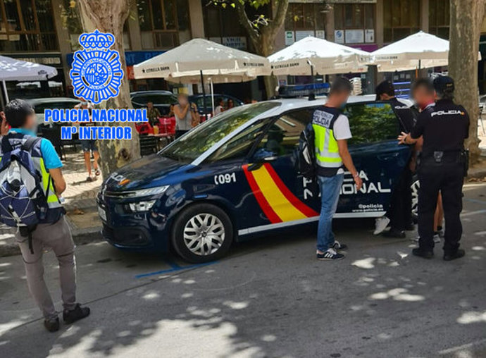 Un vehicle i agents de la policia espanyola, detenint el propietari d'un 'kebab' al passeig de l'Estació de Valls per explotació laboral de compatriotes seus. Imatge publicada l'1 d'octubre del 2020. (Horitzontal)