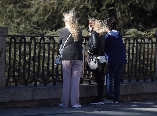 Transeúntes caminan abrigados por Madrid con la presencia de la borrasca 'Jorge' que desde el sábado se hace notar en la península dejando rachas muy fuertes de viento, lluvias y un frente frío, en Madrid (España), a 2 de marzo de 2020.