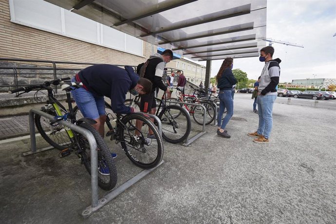Varios estudiantes colocan candados en sus bicicletas a su llegada a la UPNA 