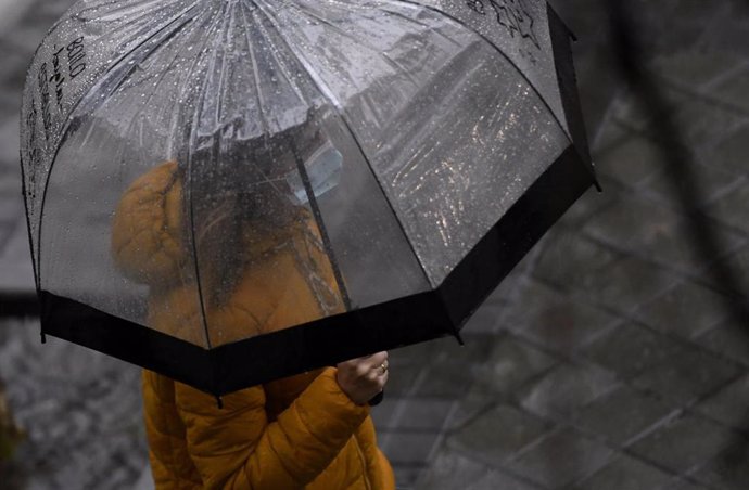 Una persona camina bajo la lluvia protegida con un paraguas, en Madrid (España) a 24 de septiembre de 2020. La ciudad ha registrado un chubasco intenso este jueves entre las 08.30 y las 10.00 horas en el que se han acumulado entre 17 y 19 litros por met