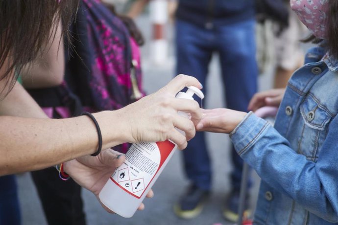 Una profesora desinfecta las manos de una alumna antes de la entrada al Colegio Público Víctor Pradera en el primer día de colegio del curso escolar 2020-2021en Pamplona