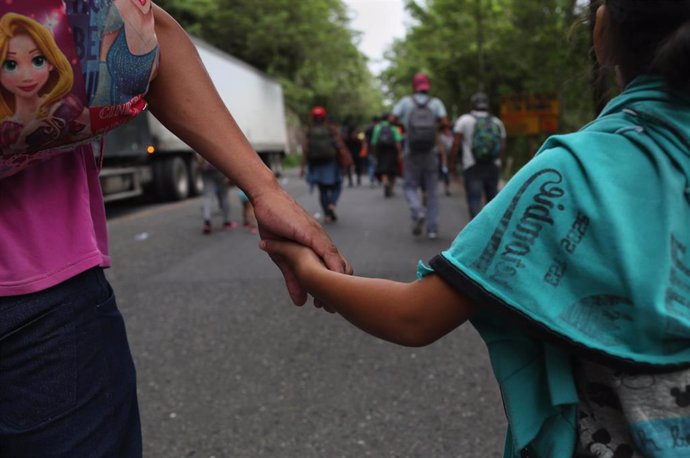 Una mujer y su hijo en una caravana migrante en Guatemala
