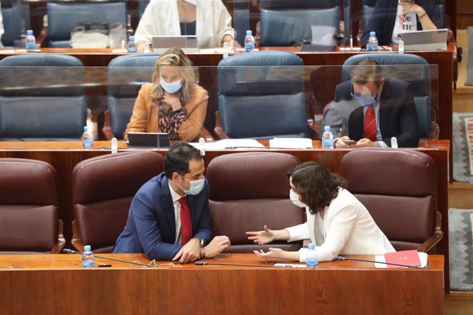 La presidenta de la Comunidad de Madrid, Isabel Díaz Ayuso, habla con el vicepresidente de la Comunidad, Ignacio Aguado, durante una sesión plenaria en la Asamblea de Madrid
