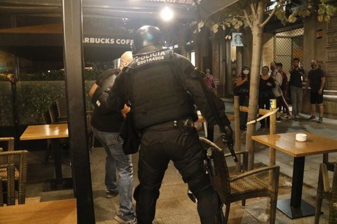 Un mosso d'esquadra agafa un manifestant durant una concentració dels CDR a Barcelona en el tercer aniversari de l'1-O. 1 d'octubre del 2020. Pla general. (Horitzontal)