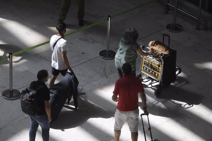 Pasajeros con maletas en el aeropuerto