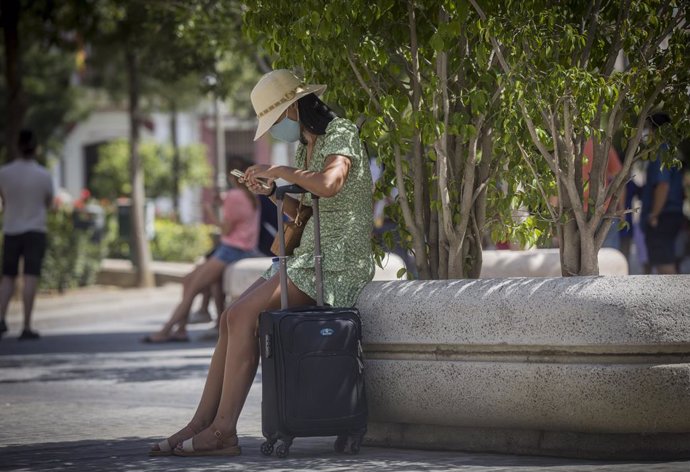 Una mujer con maleta en el entorno de la Catedral. En Sevilla (Andalucía, España), a 27 de agosto de 2020.