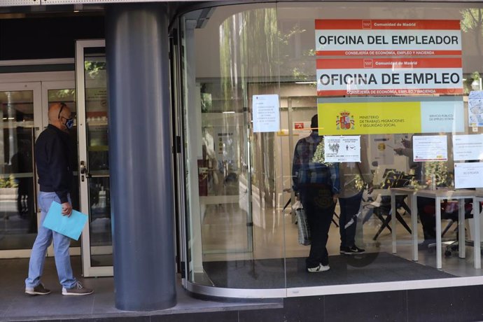 Un hombre espera en la puerta de una oficina de empleo de Madrid.