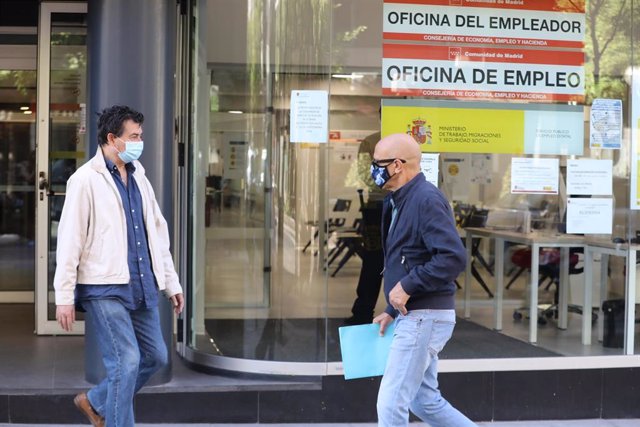 Un hombre con mascarilla pasa por una oficina de empleo de Madrid