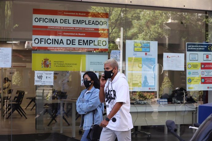 Una pareja pasa por una oficina de empleo de Madrid.